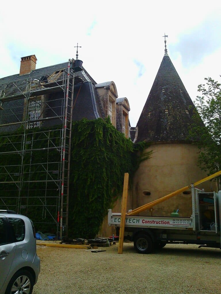 Rénovation Toiture Bâtiment Ancien - EC TECH Construction Rénovation de toiture par EC TECH Construction sur un bâtiment ancien avec échafaudage et tourelle.